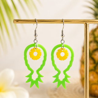 Green and yellow earrings on a gold stand with a blurred background