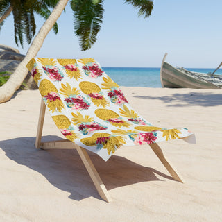 Tropical pineapple and floral beach towel with golden pineapples and pink flowers on white background
